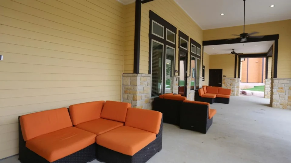 an outdoor living area with orange couches and chairs at The Latigo at Eagle Pass